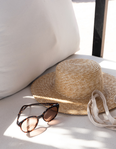 A large swimming pool surrounded by greenery, with a tall tree visible in the background.